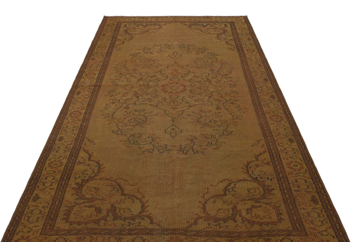 Brown vintage-style rug with a central floral medallion and ornate border pattern on a white background.