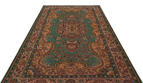 Load image 1 in gallery view. Green and brown traditional rug with a central floral medallion and ornate border pattern on a white background.