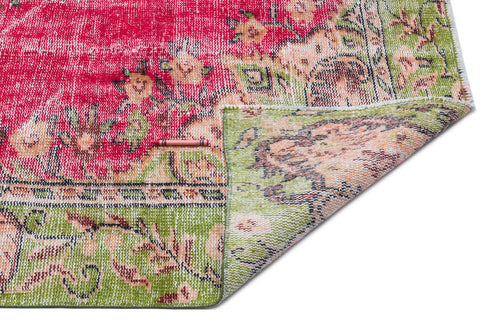 Load image 1 in gallery view. Distressed red and green floral medallion rug with a folded corner on a white background.