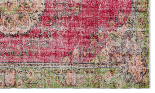 Load image 1 in gallery view. Distressed red and green vintage-style rug with a faded floral medallion pattern and a decorative border.