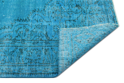 Load image 1 in gallery view. Bright turquoise distressed rug with a dark blue traditional medallion pattern, shown with a folded corner.