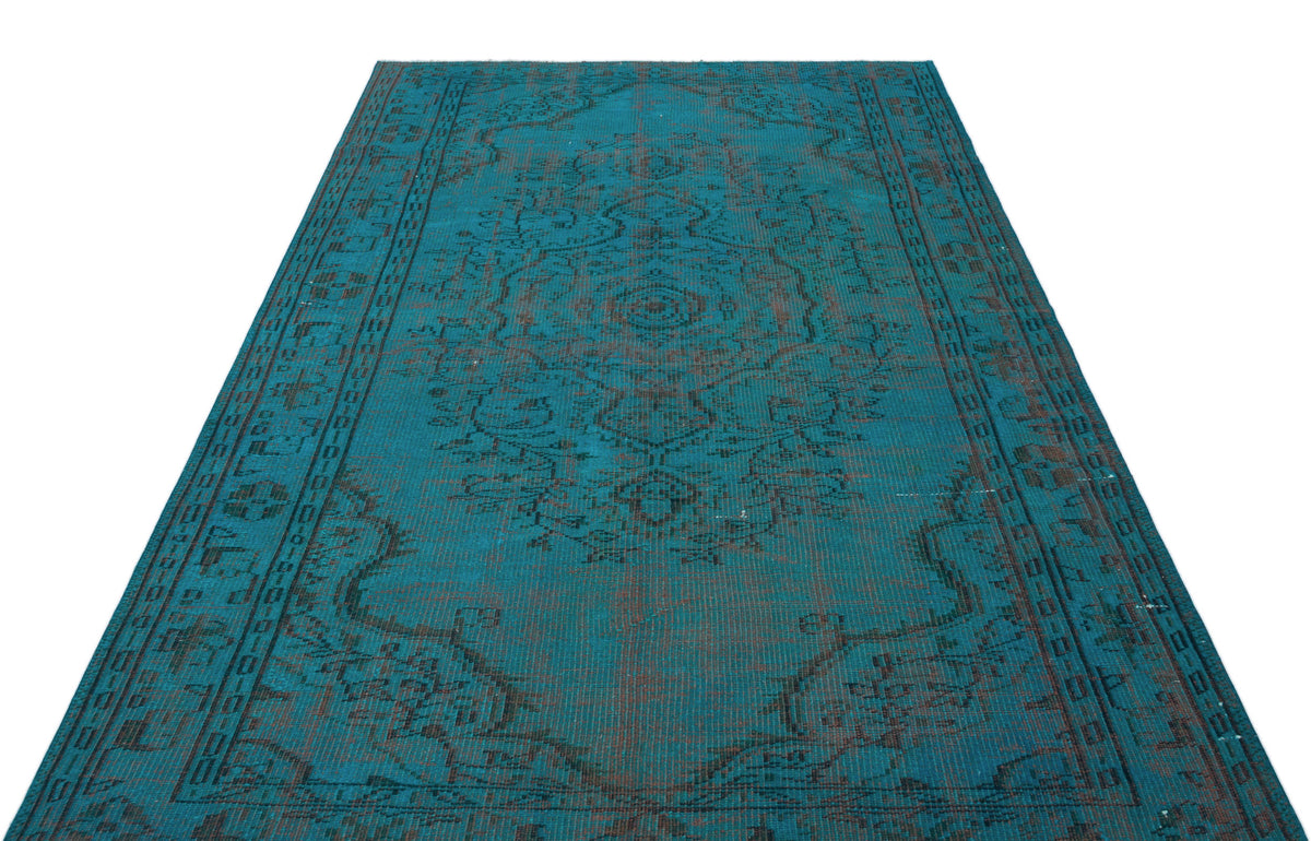 Teal and dark brown distressed rug with a traditional central medallion and ornate border pattern.