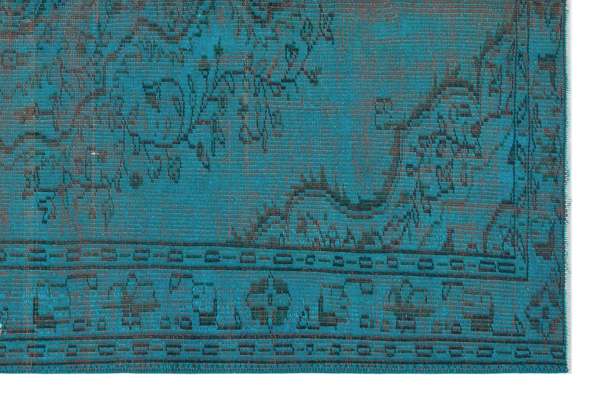 Teal and charcoal distressed rug with a traditional floral medallion pattern and a geometric border.