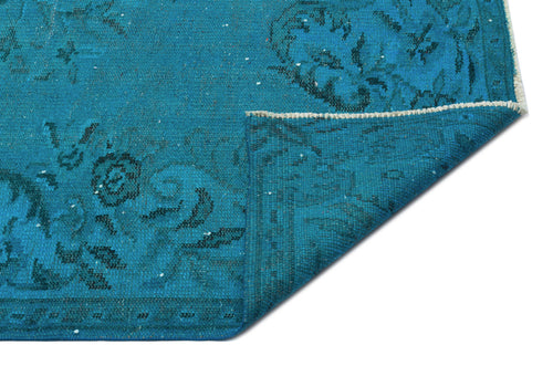 Load image 1 in gallery view. Teal distressed rug with a dark floral medallion pattern, shown with a corner folded over to reveal the underside.