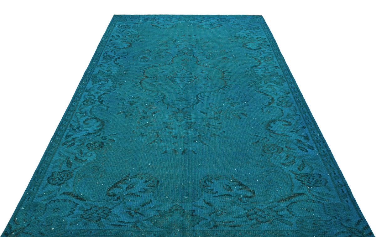 Teal area rug with a dark blue traditional floral medallion pattern and distressed finish on a white background.