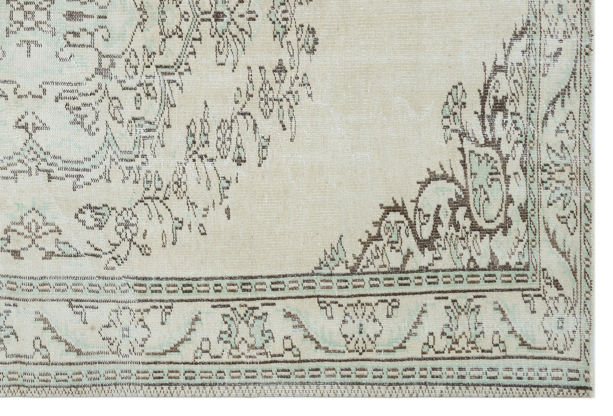 Cream and light blue rug with a distressed brown floral medallion pattern and geometric border.