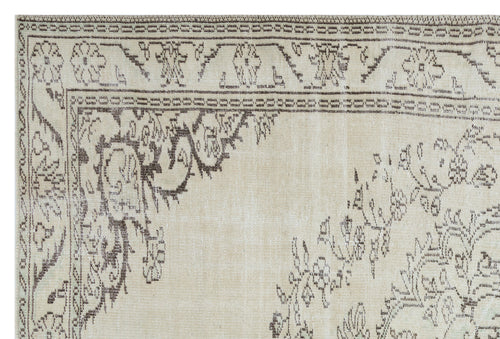 Load image 1 in gallery view. Beige rug with a dark brown distressed floral medallion pattern and a decorative geometric border.