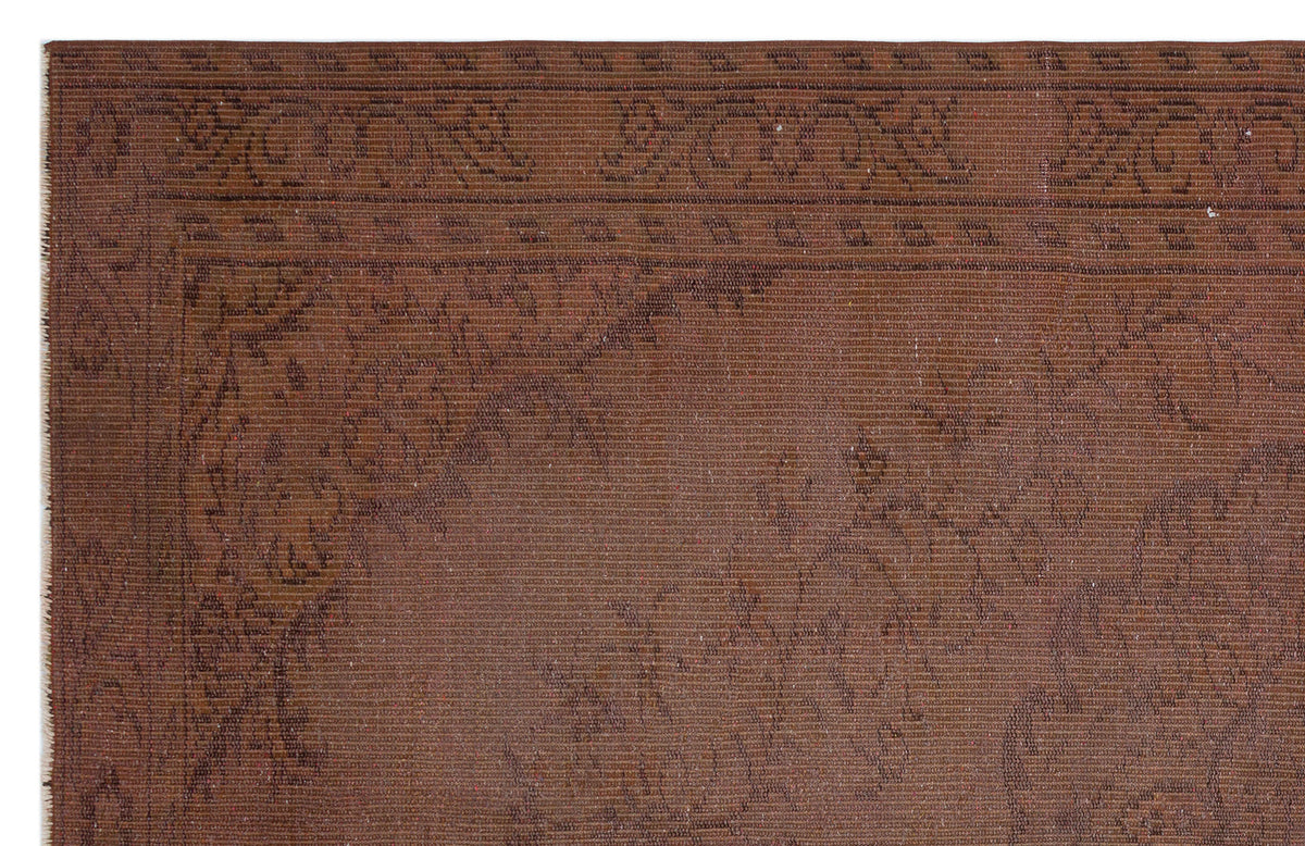 Dark brown rug with a subtle, tonal floral border and central medallion pattern.