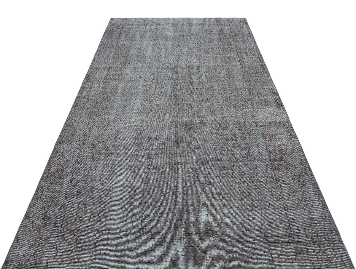 Grey and charcoal distressed runner rug with a faded traditional medallion pattern on a white background.