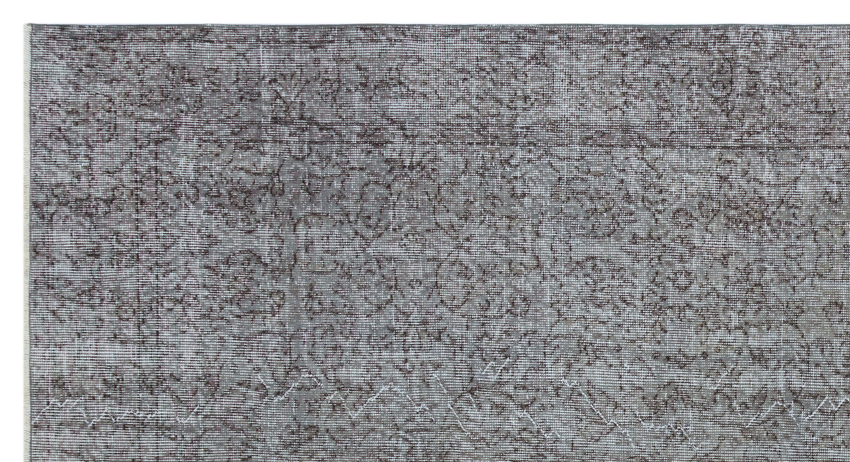 Grey and charcoal distressed rug with a traditional floral medallion pattern.