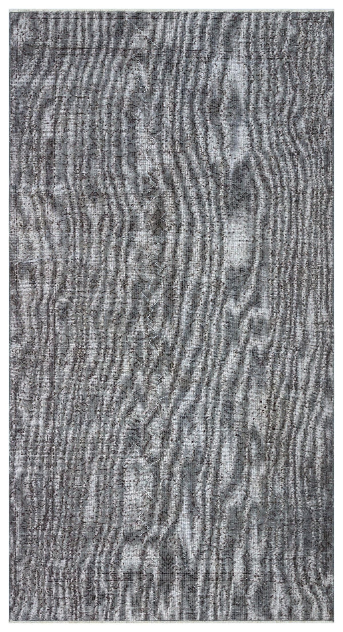 Charcoal grey distressed rug with a faint, traditional overdyed medallion pattern.