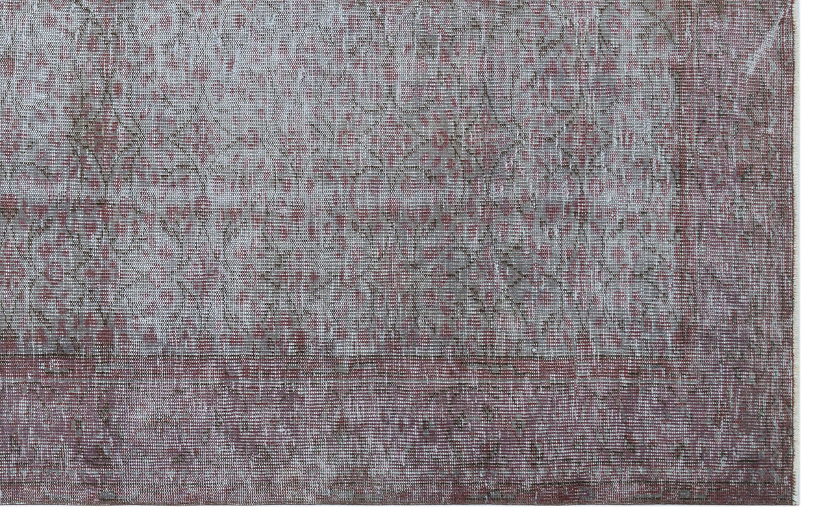 Distressed grey and muted red rug with a faded traditional medallion pattern and a wide border.