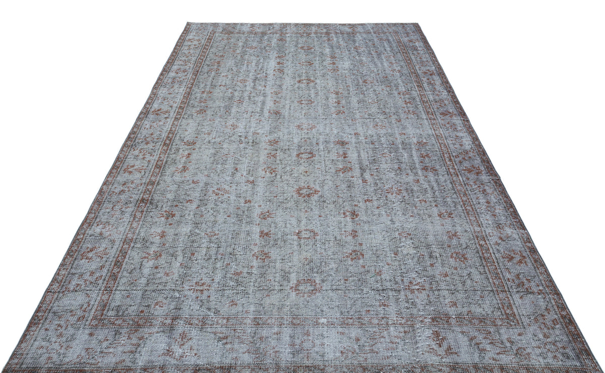 Grey and rust-colored distressed rug with a traditional medallion pattern and a bordered edge on a white background.