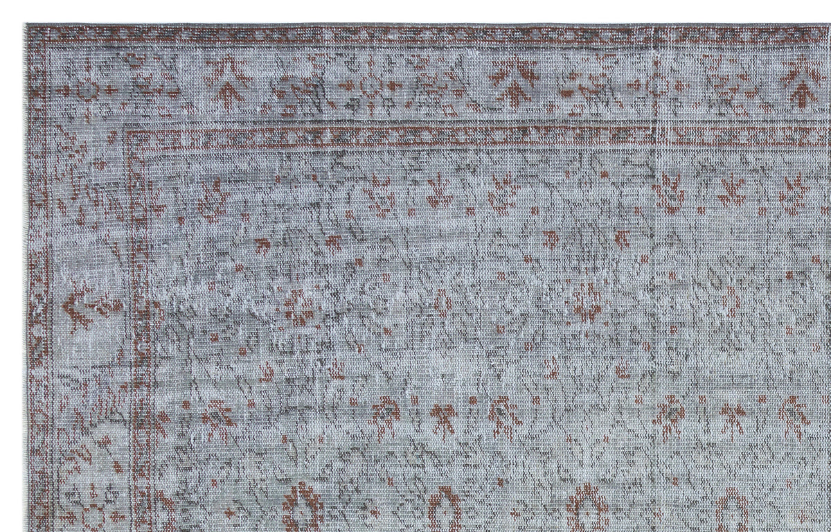 Grey and terracotta distressed rug with a traditional floral medallion pattern and a decorative border.