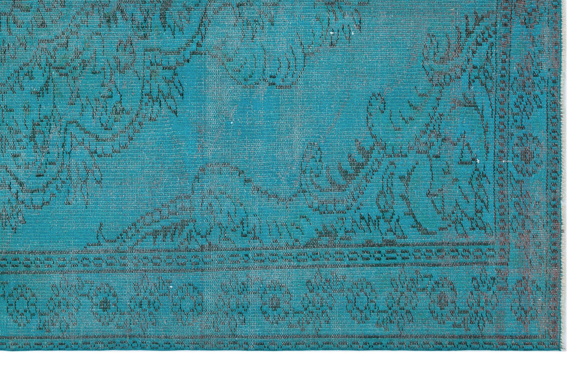 Teal distressed rug with a dark grey floral medallion pattern and a decorative border.