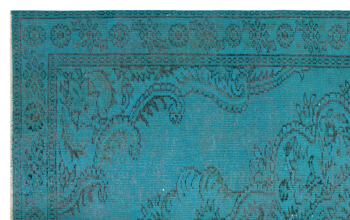 Teal rug with a dark, distressed traditional floral medallion pattern and a decorative border.