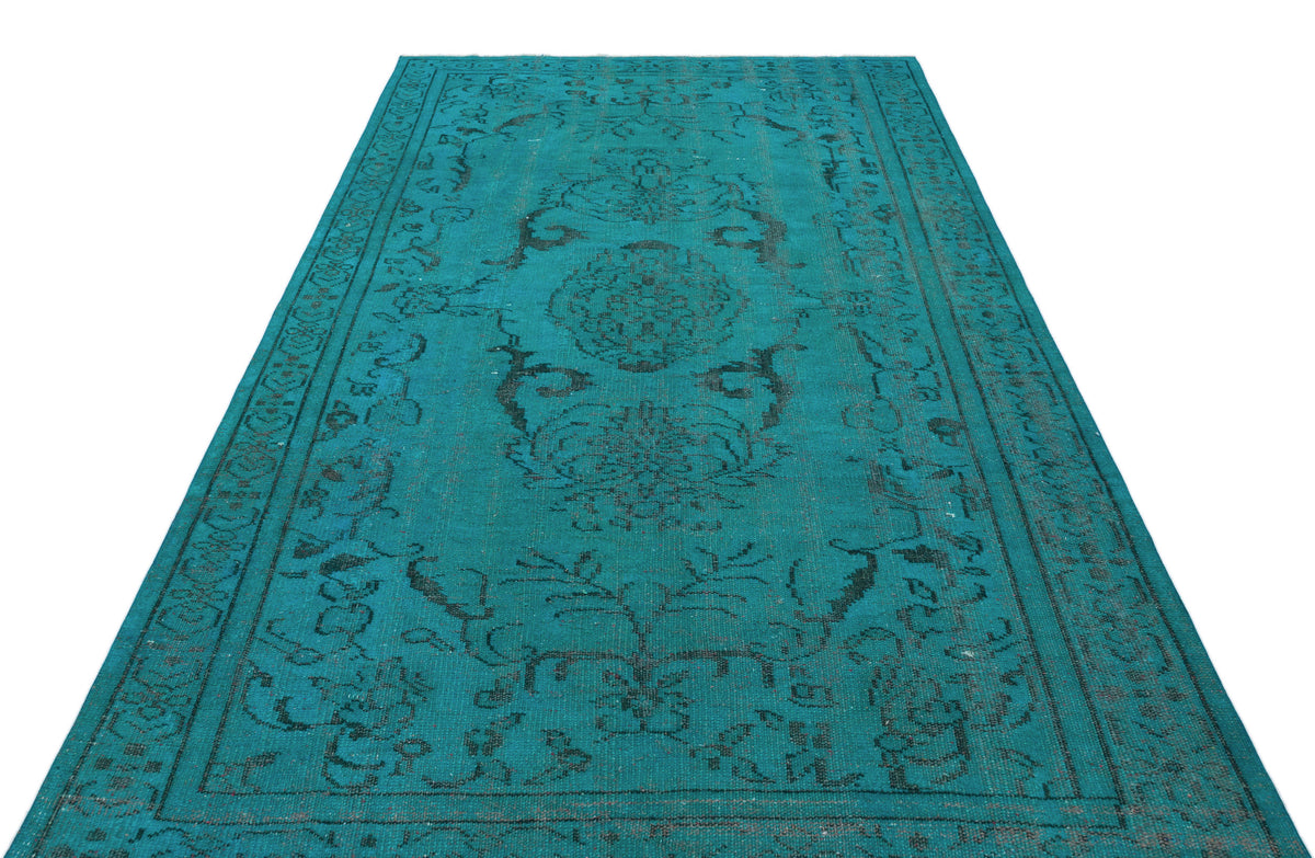 Teal rectangular rug with a distressed black traditional floral medallion pattern and a decorative border.