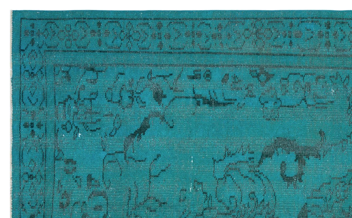 Teal rug with a black distressed traditional floral medallion pattern and a detailed border.