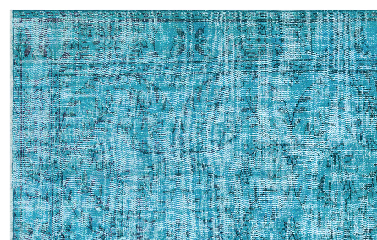Turquoise distressed rug with a faded traditional floral medallion pattern and a bordered edge.