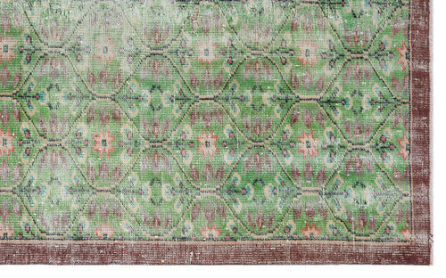 Load image 1 in gallery view. Distressed green rug with a repeating geometric diamond pattern, floral motifs, and a solid brown border.