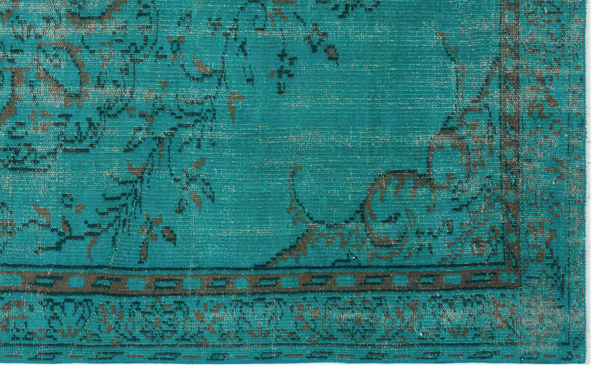 Teal rug with a distressed, dark brown traditional floral medallion pattern and a geometric border.