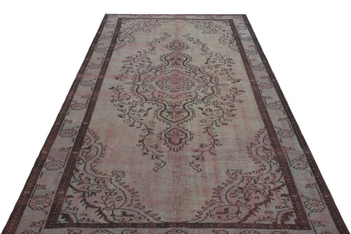 Load image 1 in gallery view. Faded pink and brown vintage-style rug with a central floral medallion and a decorative border.