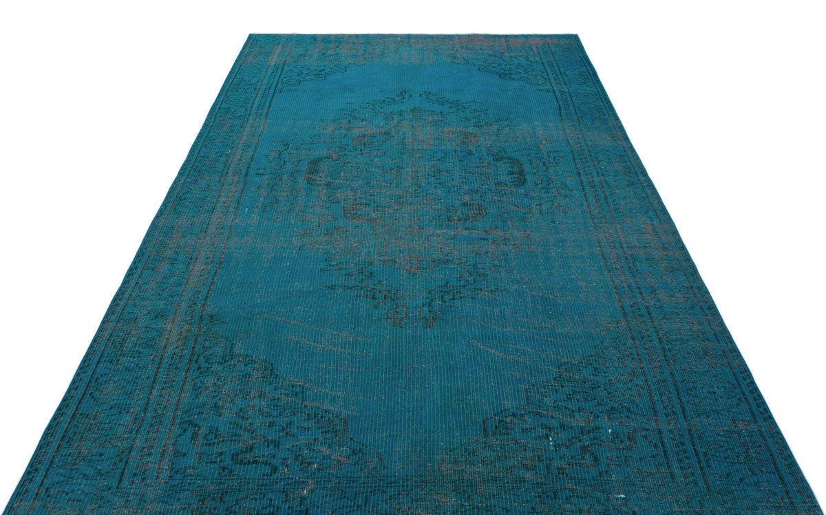 Teal vintage-style rug with a dark distressed central medallion and ornate border pattern on a white background.