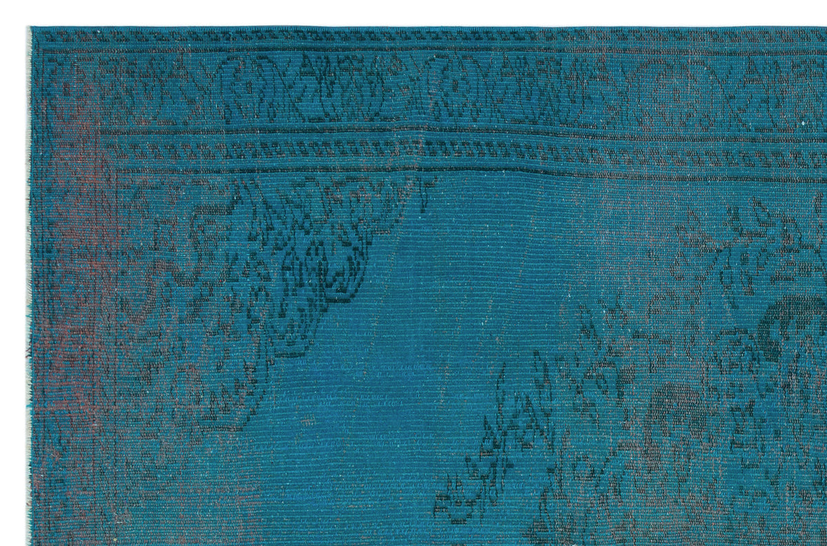 Teal rug with a dark, distressed traditional floral border and medallion pattern.