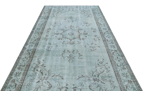 Load image 1 in gallery view. Light blue distressed rug with a central brown floral medallion and a decorative border on a white background.