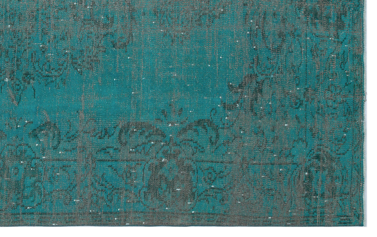 Teal and charcoal distressed rug with a faded traditional floral medallion pattern.