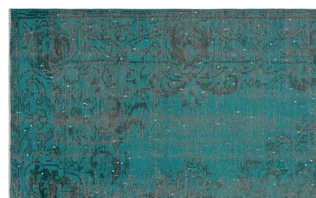 Teal and charcoal distressed rug with a faded traditional floral medallion pattern.