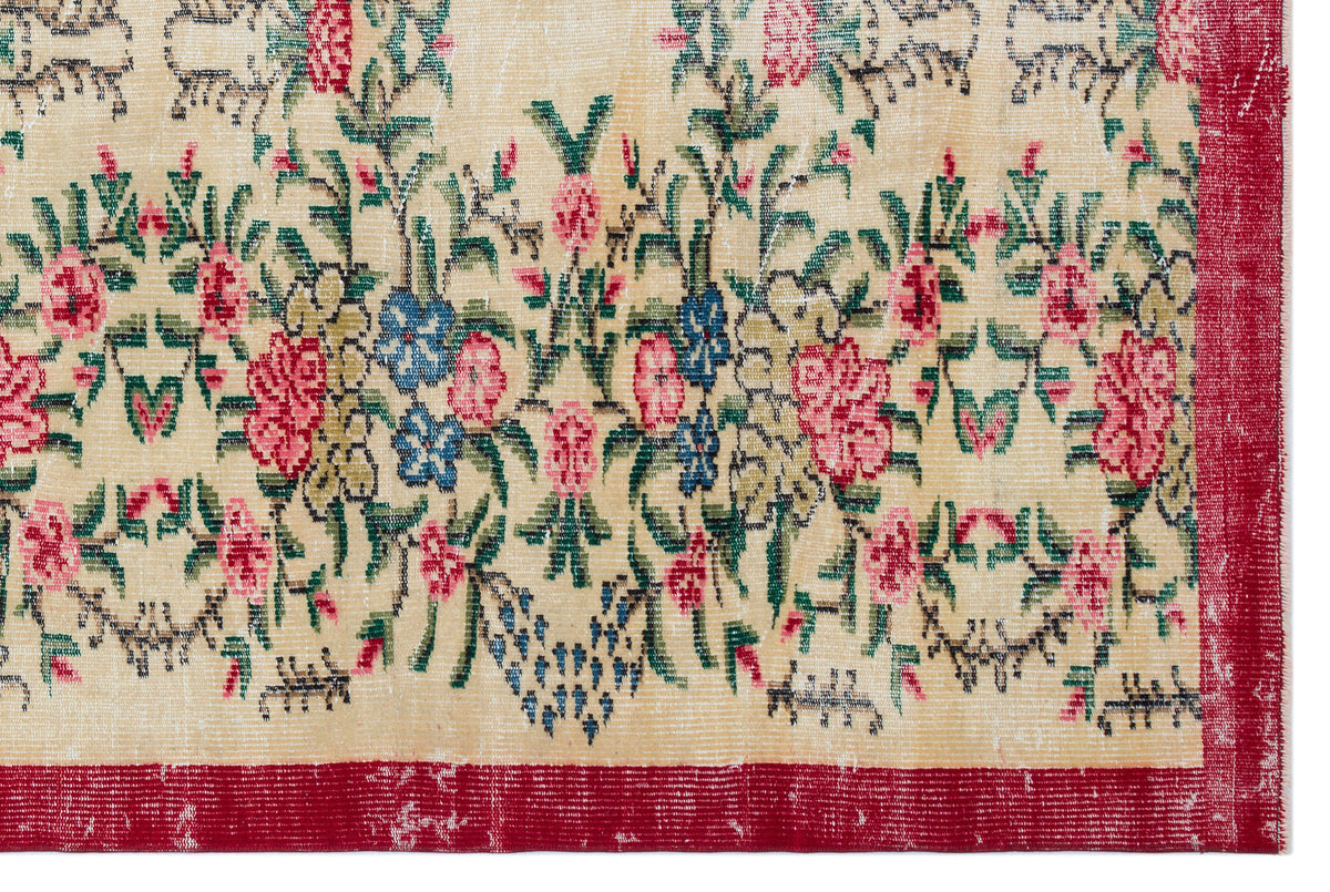 Beige rug with a floral pattern in pink, blue, and green, featuring a distressed texture and a solid red border.