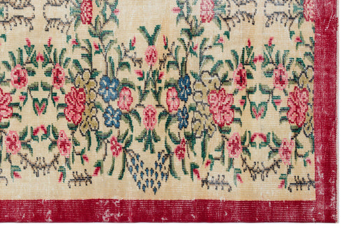 Load image 1 in gallery view. Beige rug with a floral pattern in pink, blue, and green, featuring a distressed texture and a solid red border.