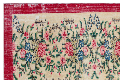 Load image 1 in gallery view. Distressed beige rug with a red border and a multi-colored floral pattern in pink, blue, and green.