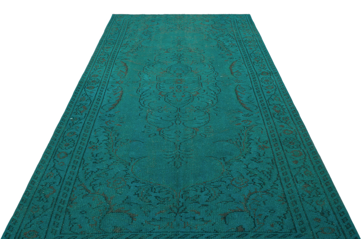 Teal vintage-style rug with a dark brown distressed floral medallion pattern on a white background.