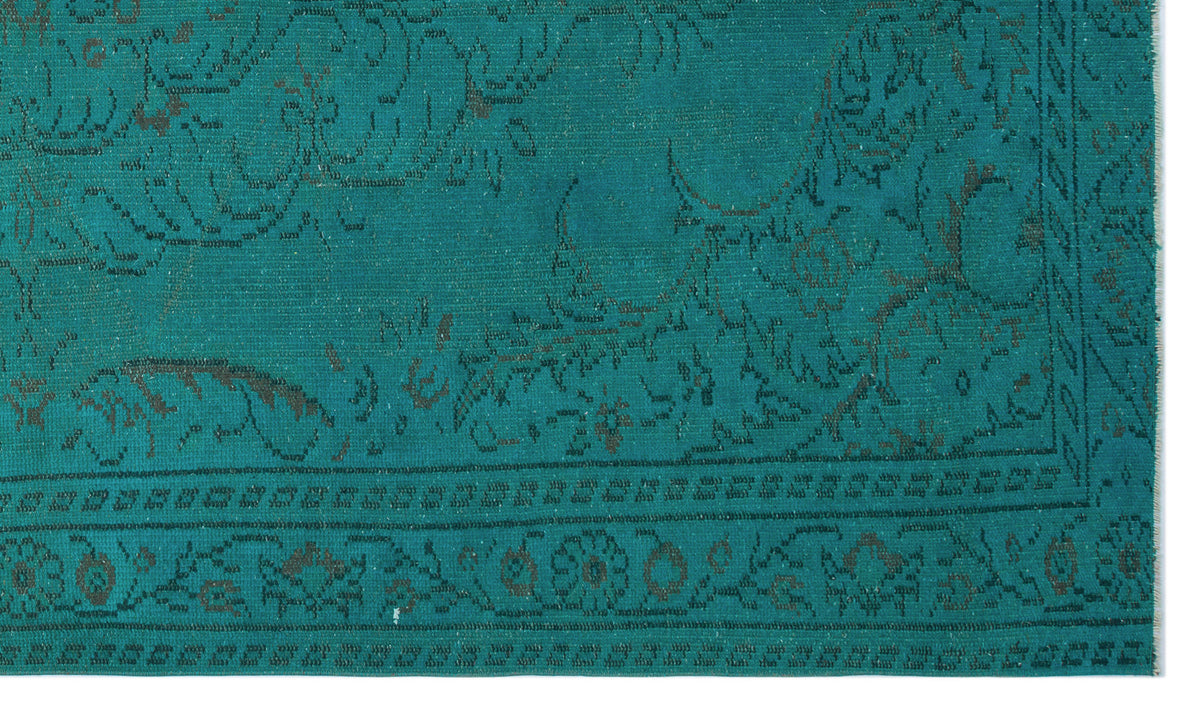 Teal rug with a dark grey distressed floral medallion pattern and a decorative border.