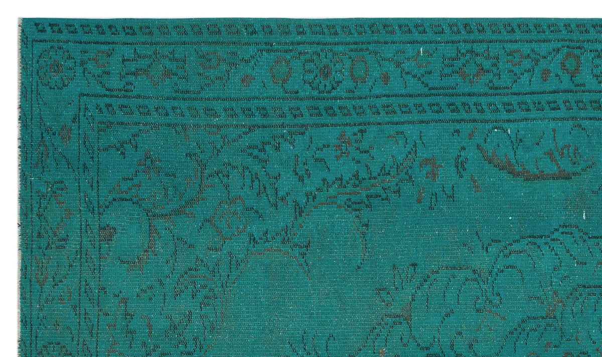 Teal rug with a dark grey distressed floral medallion pattern and a decorative border.