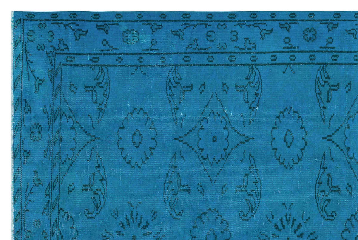 Bright blue rug with a dark blue traditional floral medallion pattern and a geometric border.