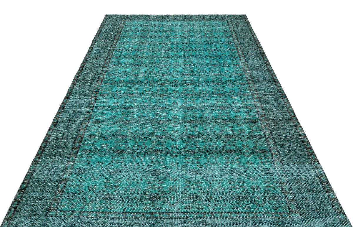 Teal and charcoal distressed vintage-style rug with a repeating medallion pattern and a wide border.