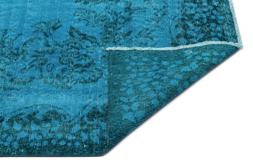 Load image 1 in gallery view. Bright blue distressed rug with a dark floral medallion pattern and a folded corner showing the woven backing.