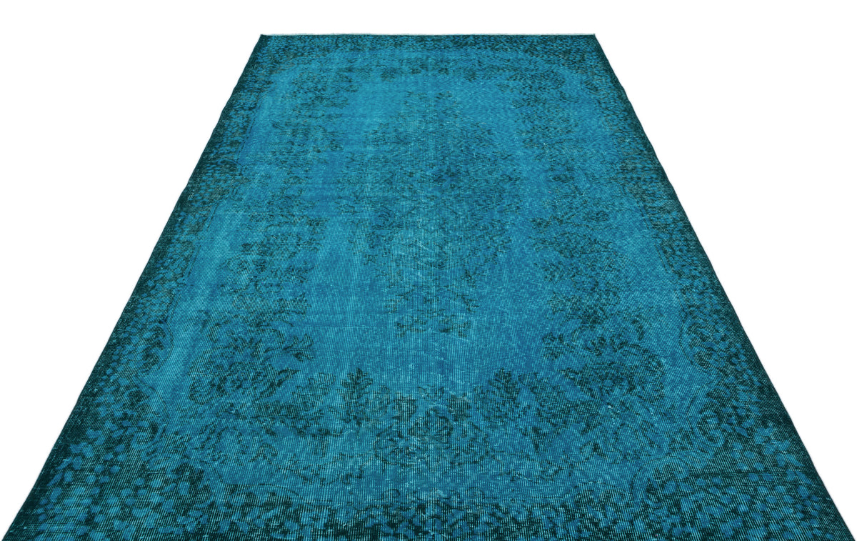 Teal distressed area rug with a traditional floral medallion pattern on a white background.