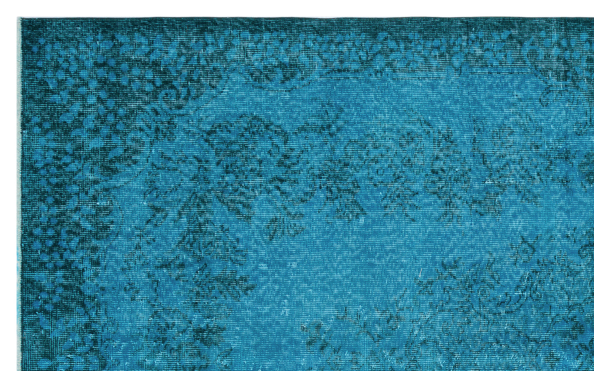 Teal and dark blue distressed rug with a faded traditional floral medallion pattern.