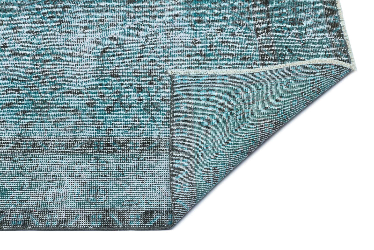 Teal and charcoal distressed vintage-style rug with a folded corner showing the woven backing on a white background.