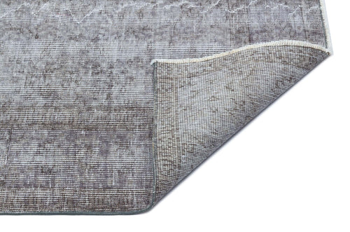 Load image 1 in gallery view. Grey and white distressed traditional rug with a faded medallion pattern, shown with a corner folded over.