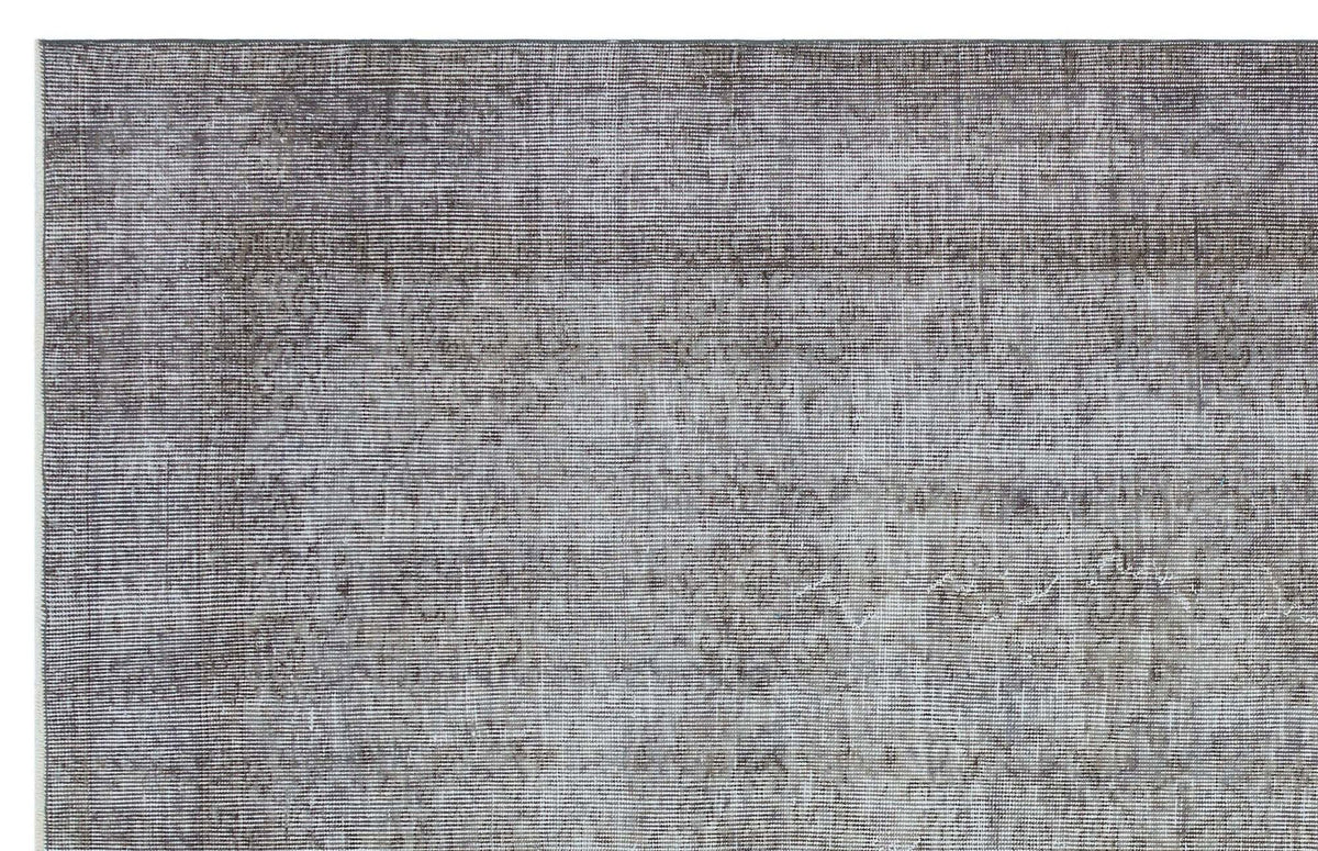 Charcoal and grey distressed rug with a faded traditional medallion pattern.