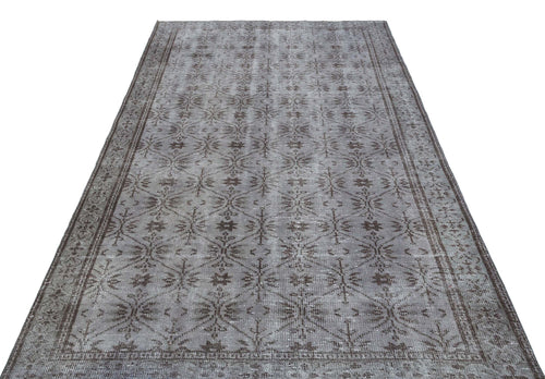 Load image 1 in gallery view. Grey and brown distressed rug with a repeating geometric floral lattice pattern and a wide decorative border.