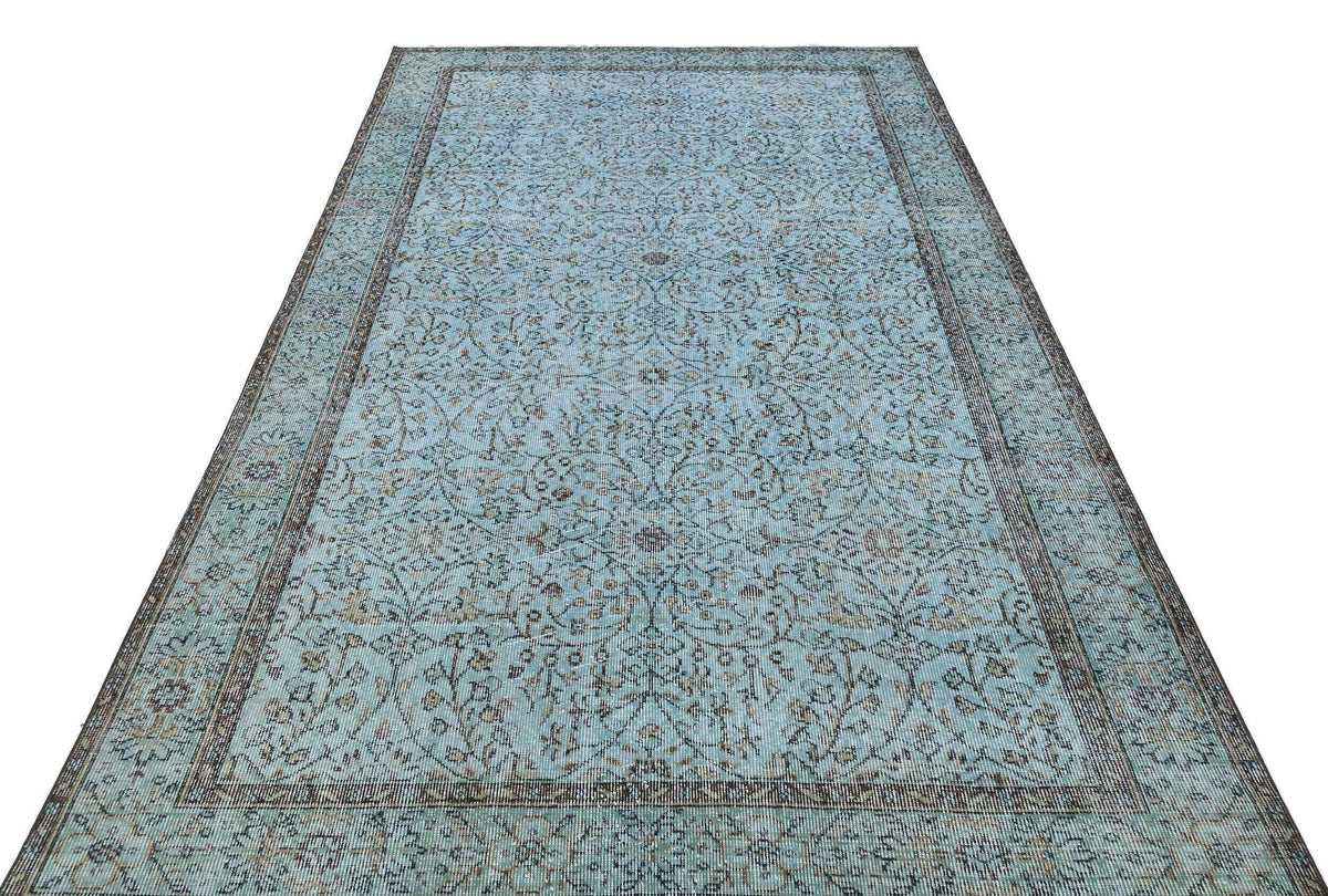 Light blue traditional rug with a dark brown floral vine pattern and a matching border on a white background.