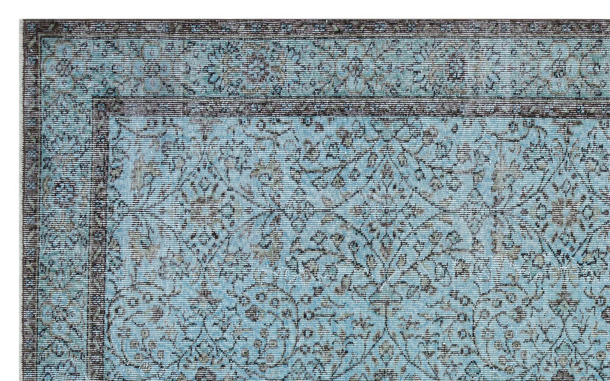 Light blue traditional rug with a dark brown floral medallion pattern and a detailed border.