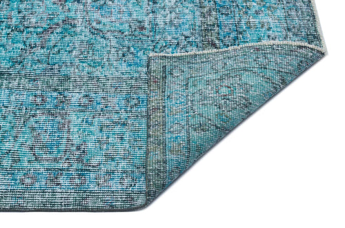 Load image 1 in gallery view. Distressed turquoise and teal area rug with a traditional medallion pattern, shown with a corner folded over.