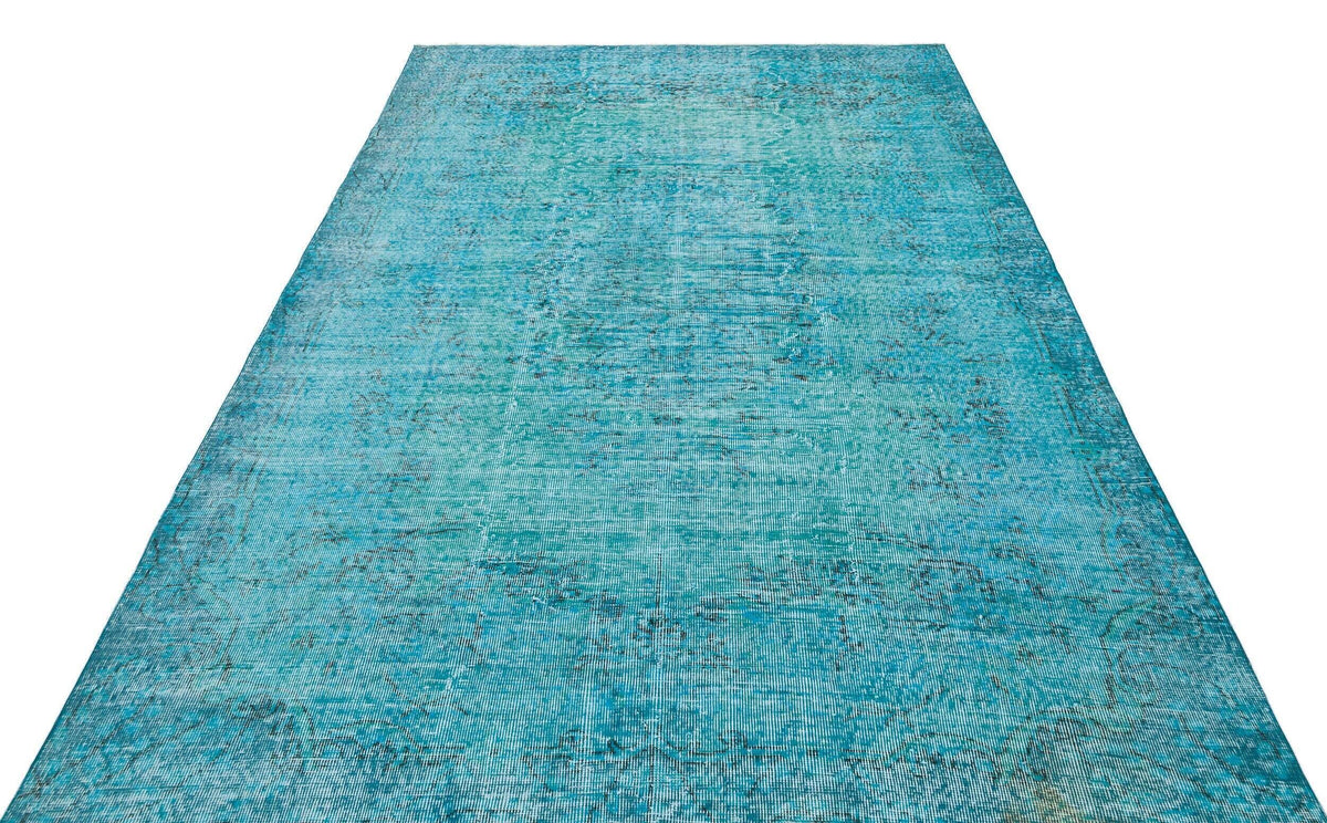 Turquoise distressed vintage-style rug with a faded traditional medallion pattern on a white background.